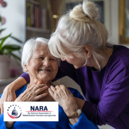 Older adult woman comforting her mother while sitting on the couch