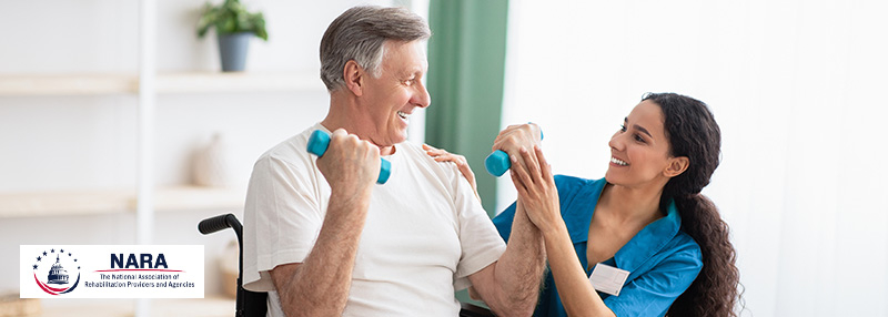 Older adult male using weights during a physical therapy session with a therapist