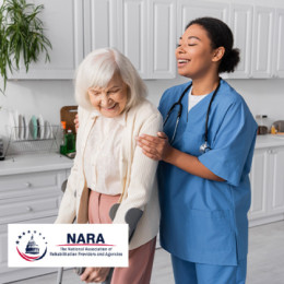 Physical Therapist from behind assisting an elderly woman with crutches walk 