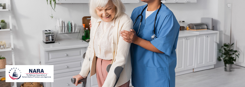 Physical Therapist from behind assisting an elderly woman with crutches walk 